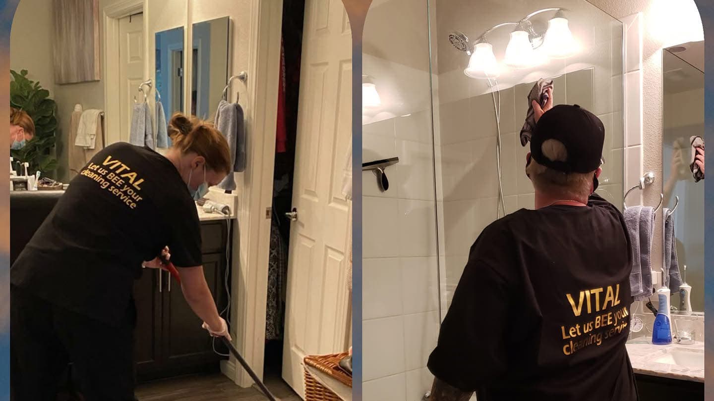 Vital Cleaning team members in branded shirts cleaning a bathroom floor and mirror